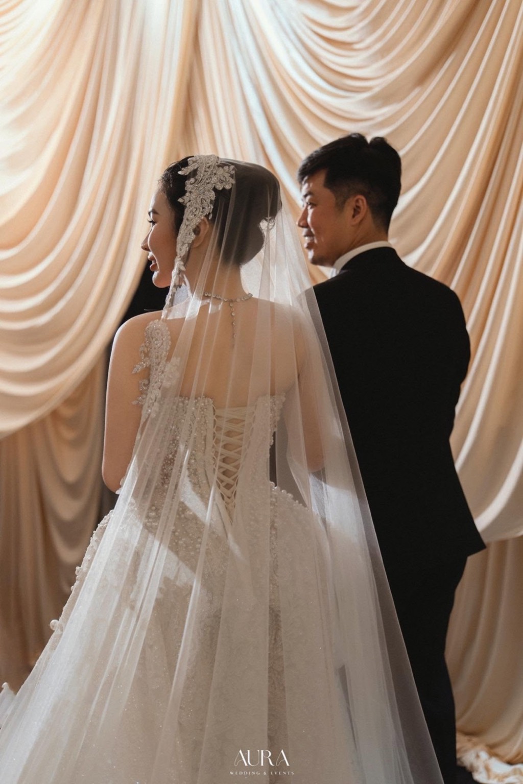Cô dâu chú rể trước nền lụa ngà xếp nếp